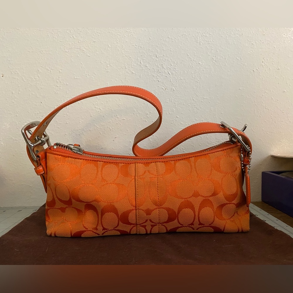 Coach orange with silver zipper purse. Like new. Clean with minimal blemishes.